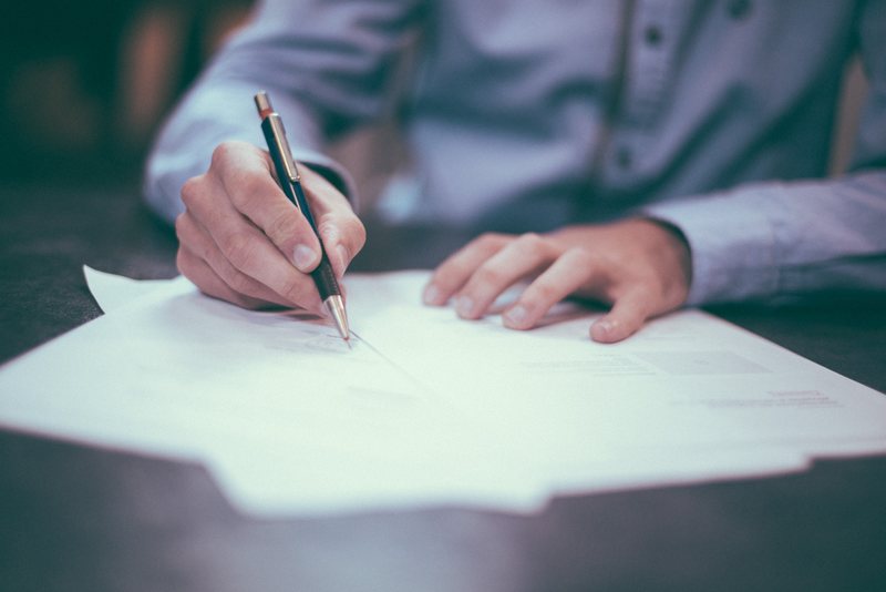 Man with pen and paper preparing for termination of lease