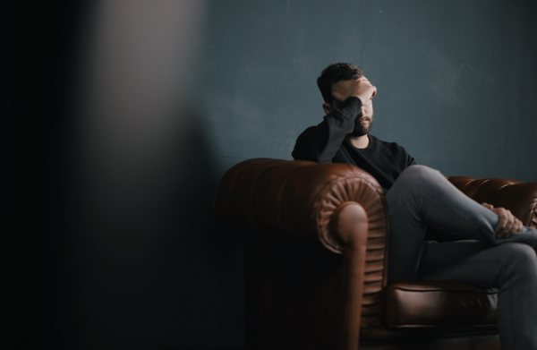 worried man sitting on a sofa wondering how to find a lost will in Australia