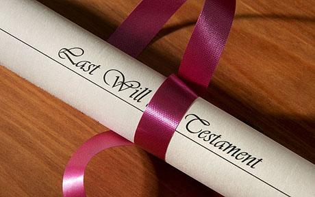 How to write a will: Last will and testament scroll on a table, tied with a pink ribbon